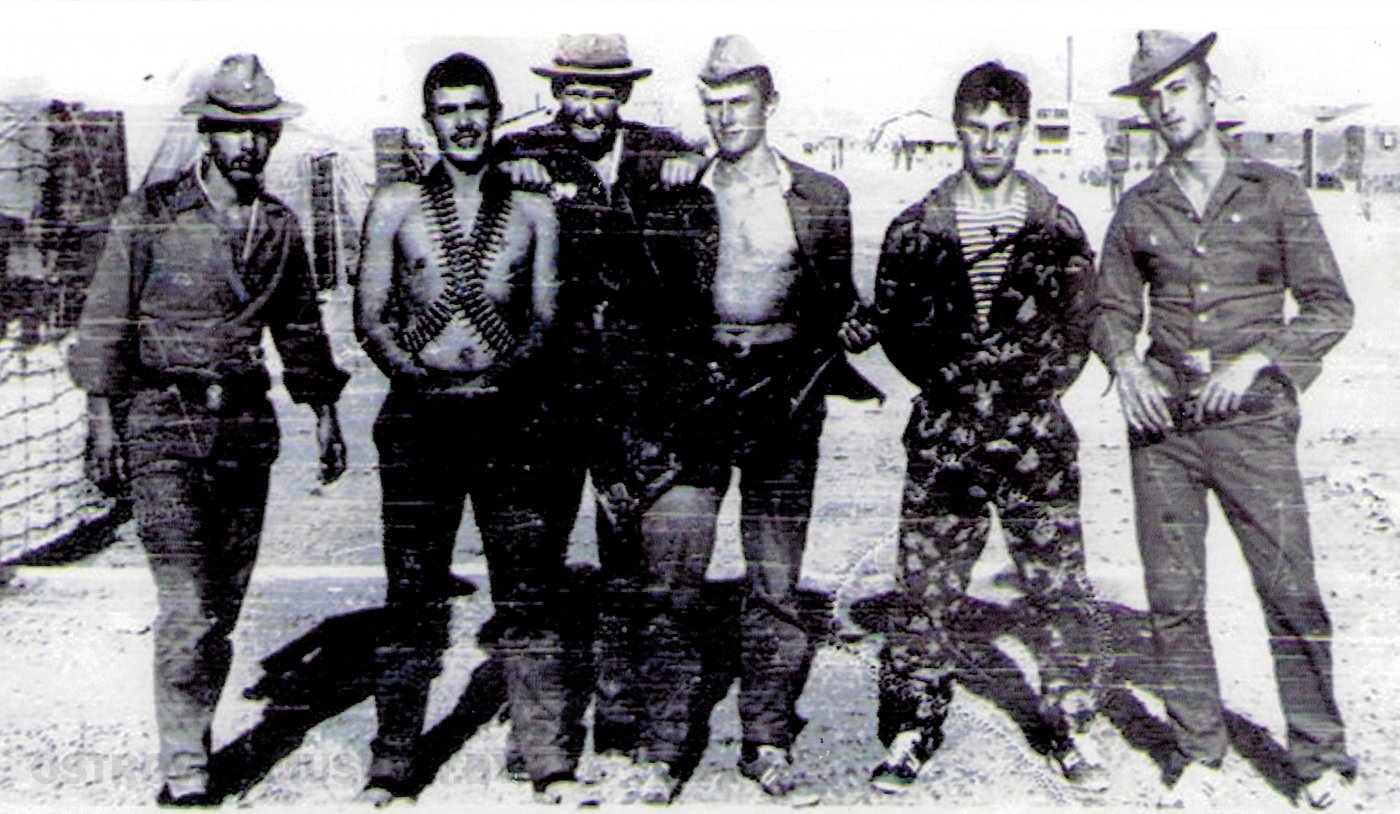 Группа солдат в форме разных видов войск на фоне сооружений военной части. Один солдат опоясан патронташем. Афганистан, 1984 г.