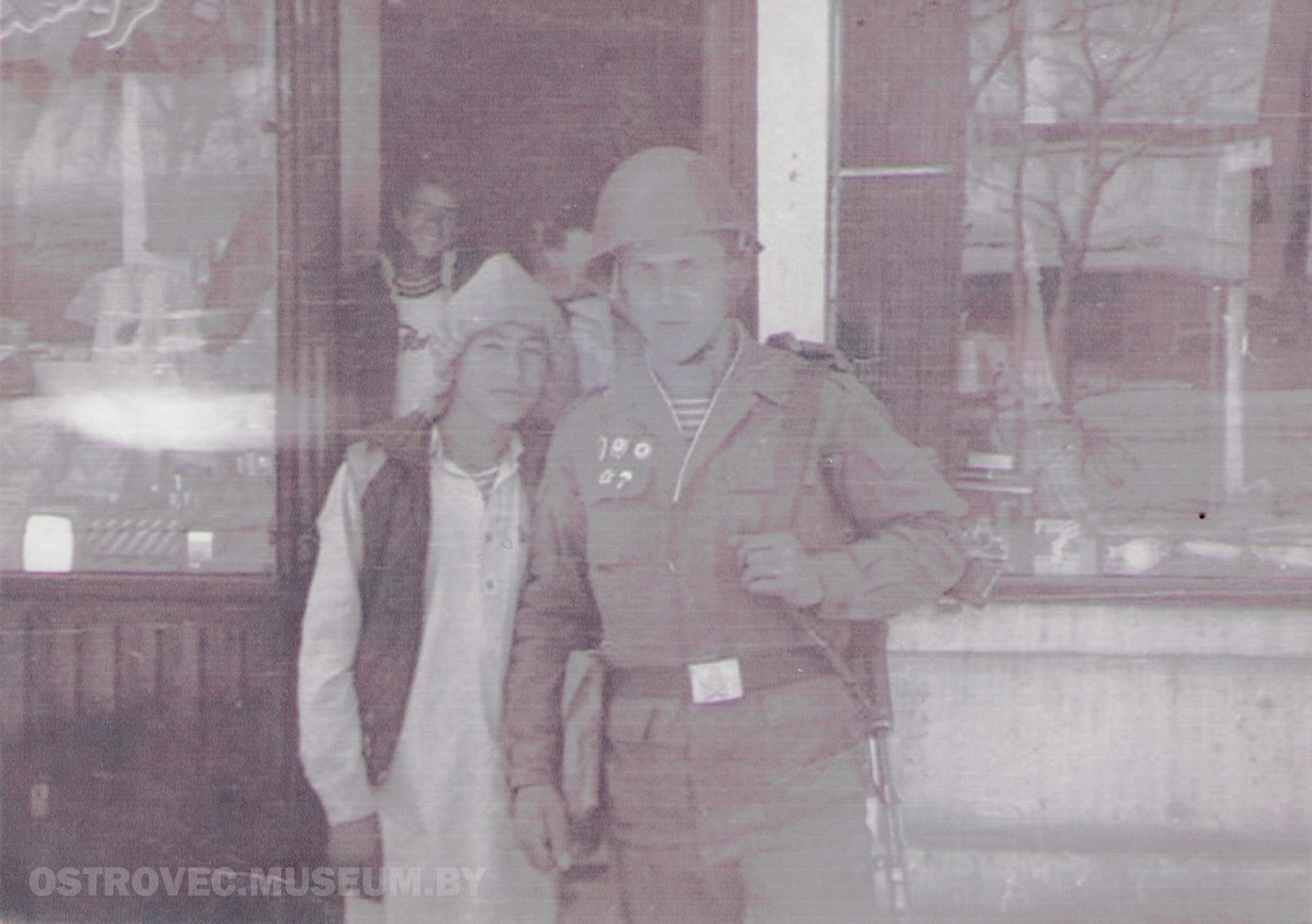 Олизар Владимир Марьянович у дверей магазина с афганским мальчиком-подростком в традиционной длинной рубахе. Афганистан, 1988 г.